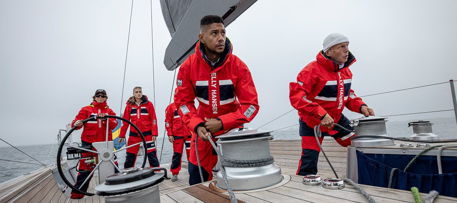 Sailing crew in red Helly Hansen Salt jackets working the winches