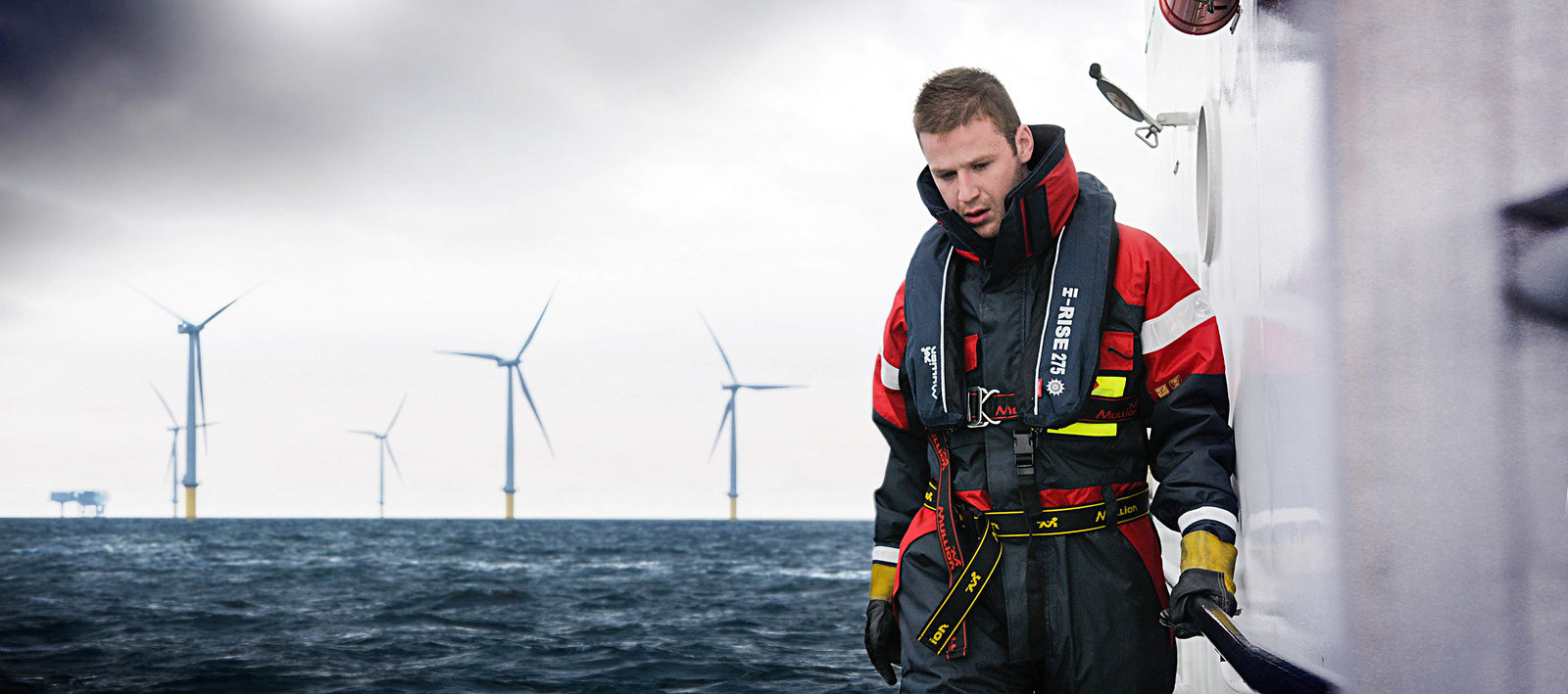 Crew member wearing a Mullion lifejacket on a vessel at an offshore wind farm