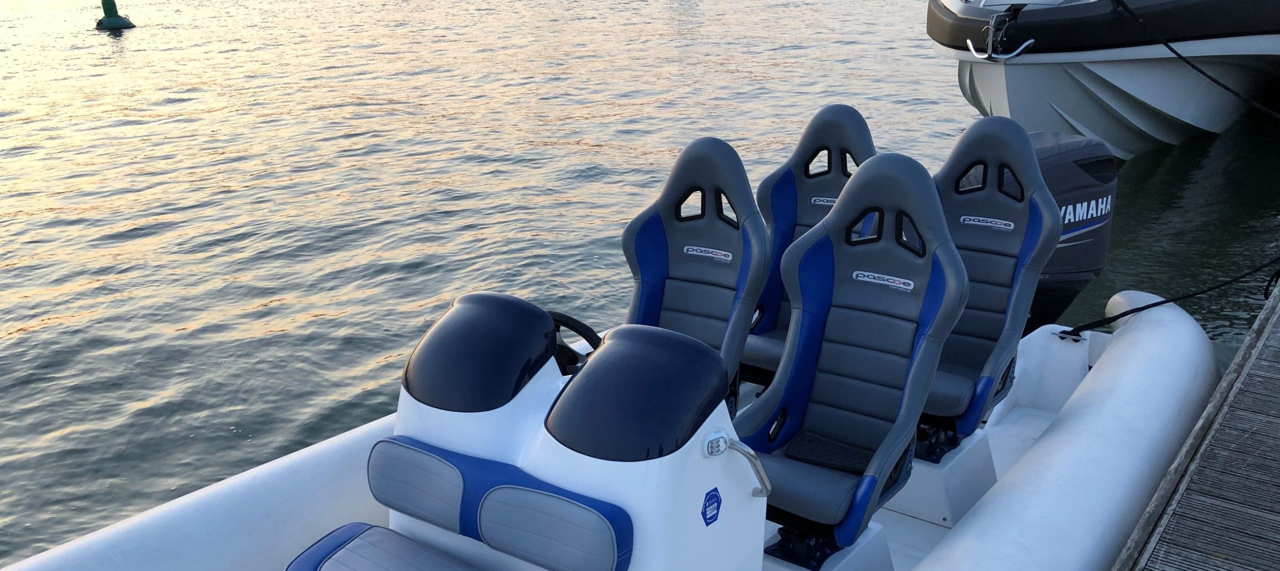 Rigid inflatable boat with suspension seats moored on a river at sunset